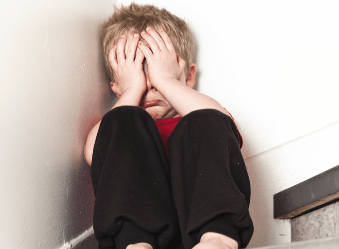 Boy crying with head in hands
