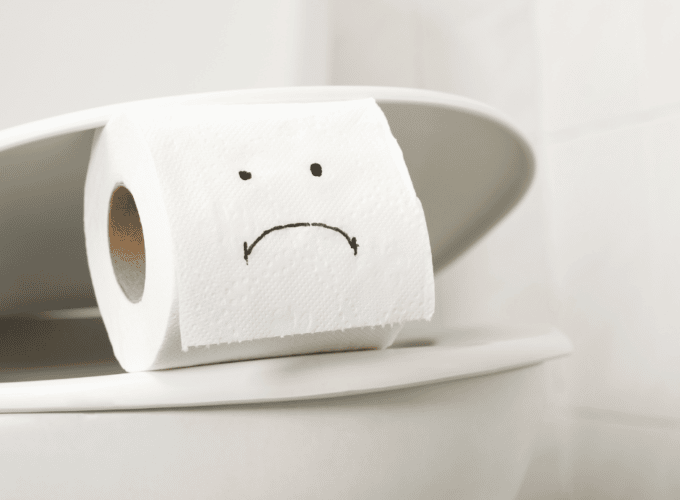 Toilet and toilet roll with sad face