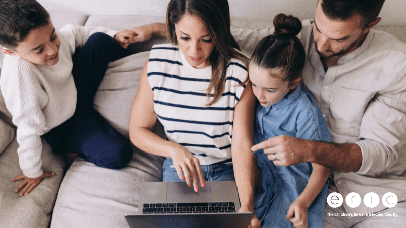 A family sitting together on the sofa using a laptop