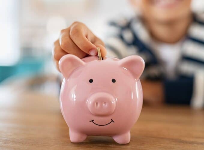Hand putting money in piggy bank
